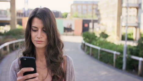 Schöne-Frau,-Die-Mit-Der-Smartphone-Technologie-App-Durch-Die-Stadt-Spaziert