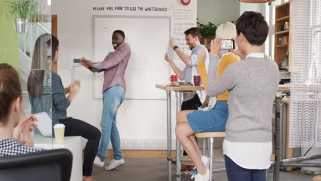 Crazy-happy-african-american-businessman-dancing-doing-victory-dance-in-team-meeting-celebrating-success-achievement