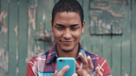 Slow-Motion-Portrait-of-mixed-race-man-smiling-using-smart-phone