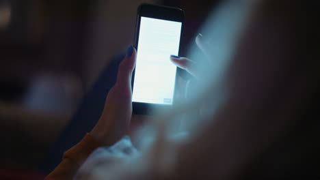 Woman-reading-document-late-at-night-at-home-on-smart-phone
