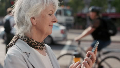 Zeitlupenporträt-Einer-Glücklichen-Reifen-Alten-Frau,-Die-Ihr-Smartphone-Benutzt