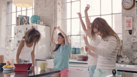 Young-group-of-girl-friends--dancing-in-kitchen-wearing-pyjamas