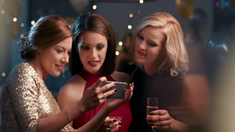 Beautiful-woman-at-glamorous-party-taking-photo-with-smart-phone-for-social-media-sharing-of-sexy-fashion-event
