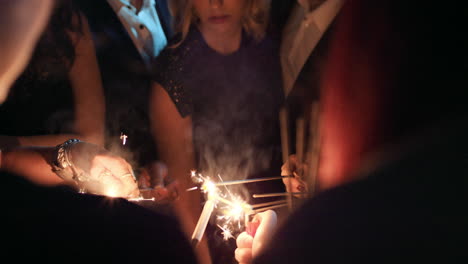 Sexy-group-of-friends-at-glamorous-party-lighting-sparklers