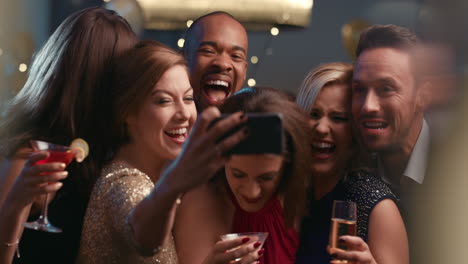 Smiling-group-of-friends-celebrate-evening-event-with-selfie-at-party
