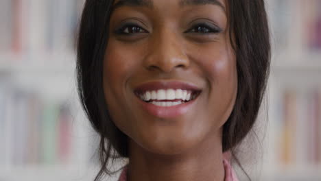 Porträt-Einer-Glücklichen-Afroamerikanischen-Studentin,-Die-Vor-Dem-Bücherregal-In-Der-Universitätsbibliothek-Lächelt
