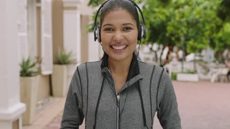 portrait-of-young-woman-wearing-earphones-smiling-happy-enjoying-listening-to-music-in-urban-city-street