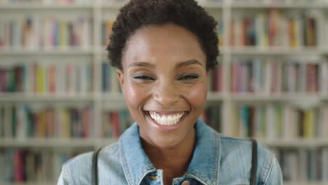 Portrait-African-American-woman-student-smiling-bookshelf-library-university