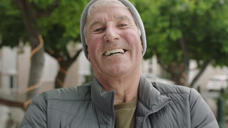 portrait-of-cheerful-elderly-caucasian-man-laughing-happy-looking-at-camera-in-urban-city-background