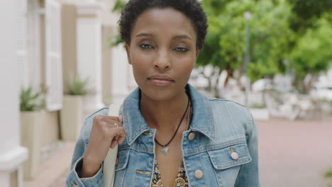 portrait-of-attractive-african-american-woman-commuter-looking-serious-pensive-at-camera-wearing-denim-jacket-in-city