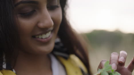 close-up-of-ladybug-insect-crawling-on-green-leaf-young-indian-woman-holding-plant-smiling-enjoying-looking-at-little-ladybird