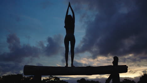 Silouette-Einer-Jungen-Frau-In-Yoga-Pose,-Meditierend,-Balancierend-Im-Hintergrund-Der-Abenddämmerung