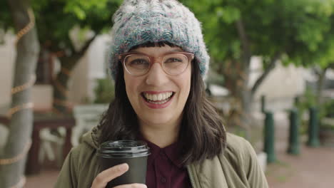 portrait-of-friendly-hipster-woman-wearing-funky-glasses-smiling-cheerful-at-camera-holding-coffee-beverage-enjoying-relaxed-urban-lifestyle