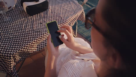 young-woman-using-smartphone-browsing-online-sending-text-messages-enjoying-sharing-summer-vacation-experience-relaxing-on-balcony-in-rustic-villa-close-up-virtual-reality