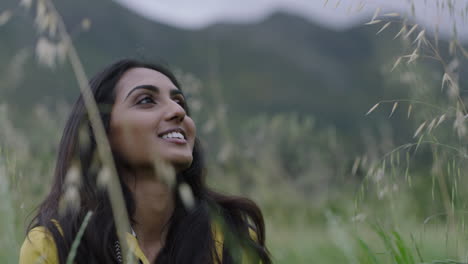 attractive-young-indian-woman-hiker-looking-up-enjoying-calm-travel-adventure-in-calm-countryside-background-smiling-happy-independent