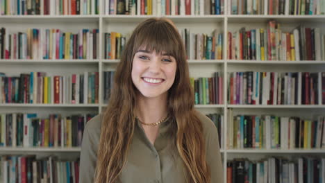 portrait-of-young-pretty-librarian-woman-smiling-happy-looking-at-camera-in-library-bookshelf-background