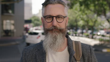 portrait-of-mature-sophisticated-bearded-man-wearing-glasses-staring-contemplative-looking-at-camera