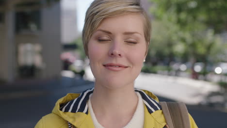 Porträt-Einer-Schönen-Blonden-Frau,-Die-Im-Städtischen-Hintergrund-Nachdenklich-Lächelt-Und-Eine-Gelbe-Jacke-Trägt
