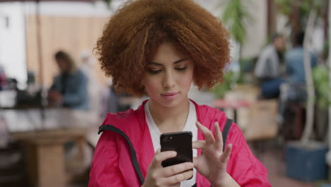 portrait-of-young-mixed-race-woman-using-smartphone-texting-browsing-mobile-phone-messaging-in-vibrant-urban-background-people-restuarant
