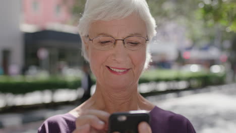 Hermoso-Retrato-De-Una-Anciana-Elegante-Sonriendo-Feliz-Enviando-Mensajes-De-Texto-Navegando-Usando-Un-Teléfono-Inteligente