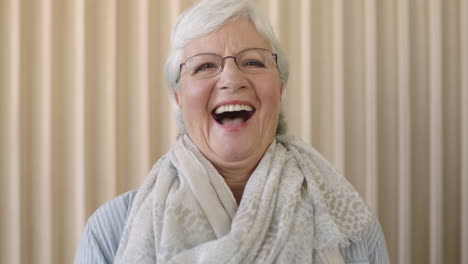 Porträt-Einer-Schönen-älteren-Frau-Im-Ruhestand,-Die-Glücklich-Lacht-Und-Positiv-In-Die-Kamera-Blickt-Und-Einen-Weißen-Schal-Trägt