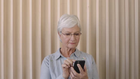 Retrato-De-Una-Hermosa-Anciana-Jubilada-Usando-Un-Teléfono-Inteligente-Enviando-Mensajes-De-Texto-Navegando-Mirando-A-Una-Anciana-Pensativa-Con-Gafas