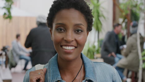 Porträt-Einer-Glücklichen-Afroamerikanischen-Frau,-Die-Fröhlich-Lächelt-Und-In-Die-Kamera-Blickt.-Sie-Trägt-Eine-Jeansjacke-Und-Genießt-Den-Entspannten-Urbanen-Studentenlebensstil