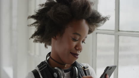 close-up-portrait-of-african-american-woman-using-smartphone-texting-browsing-enjoying-social-media-messaging-online-in-apartment-window-background