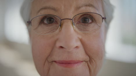 Nahaufnahme-Porträt-Einer-Schönen-älteren-Frau-Im-Ruhestand,-Die-Nachdenklich-In-Die-Kamera-Blickt-Und-Eine-Brille-Im-Hintergrund-Der-Wohnung-Trägt