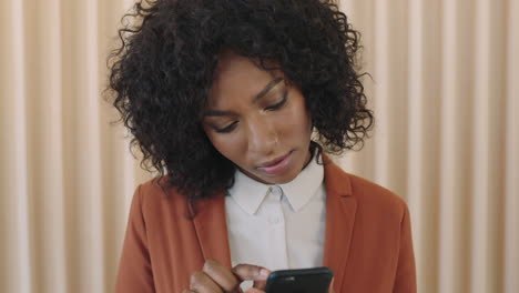 Nahaufnahme-Des-Porträts-Einer-Stilvollen-Jungen-Afroamerikanischen-Frau-Mit-Afro-Frisur,-Die-Fokussiert-Aussieht-Und-Mithilfe-Der-Smartphone-Social-Media-App-SMS-Browsing-Durchführt
