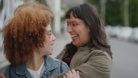 portrait-of-happy-woman-suprise-kiss-hugging-friend-diverse-friends-embracing-enjoying-friendship-together-in-urban-city-street-background-slow-motion