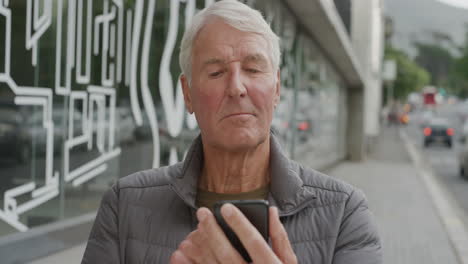 Porträt-Eines-älteren-Kaukasischen-Mannes,-Der-Smartphone-SMS-Nutzt-Und-Online-Surft-Und-SMS-Nachrichten-über-Die-Mobiltelefon-Technologie-App-Auf-Der-Städtischen-Straße-Sendet