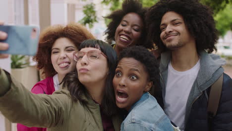 portrait-of-happy-group-of-multi-ethnic-friends-posing-taking-selfie-photo-using-smartphone-enjoying-fun-making-faces-students-celebrating-vacation-together
