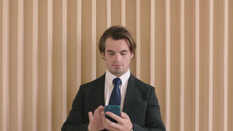 portrait-of-attractive-young-successful-businessman-checking-messages-using-smartphone-professional-male-entrepreneur-texting-browsing-working-mobile