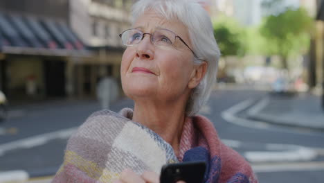 Porträt-Einer-älteren-Frau,-Die-Ihr-Smartphone-Nutzt-Und-Online-Nach-Wegbeschreibungen-Sucht.-Ältere-Kaukasische-Frau-Sieht-Verloren-In-Der-Stadtstraße-Aus
