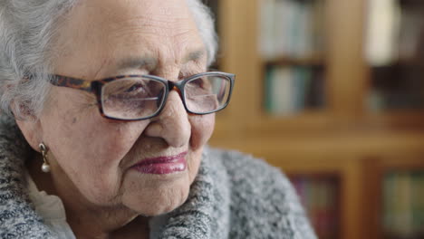 portrait-of-beautiful-elderly-woman-looking-out-window-longing-sad-removes-glasses-tired-lonely