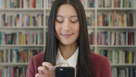 Porträt-Einer-Süßen-Jungen-Asiatischen-Studentin,-Die-SMS-Schreibt-Und-Mithilfe-Mobiler-Smartphone-Technologie-Online-Nach-Informationen-In-Der-Bibliothek-Recherchiert