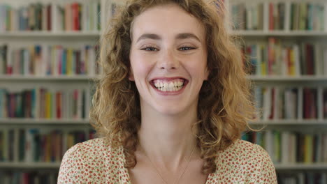 close-up-portrait-of-beautiful-young-red-head-woman-student-laughing-cheerful-at-camera-in-library-bookshelf-background