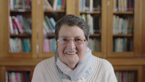 Porträt-Einer-Freundlichen-älteren-Frau,-Die-Fröhlich-In-Die-Kamera-Lächelt-Und-Einen-Schal-Im-Hintergrund-Der-Bibliothek-Trägt