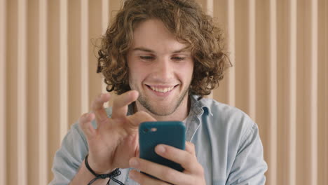 close-up-portrait-of-cute-friendly-young-man-texting-browsing-using-smartphone-mobile-technology-smiling-happy-enjoying-connection