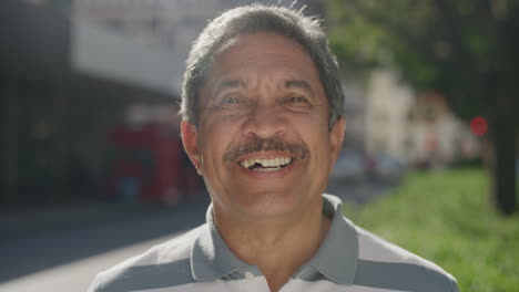 portrait-of-senior-hispanic-man-smiling-happy-enjoying-successful-retirement-lifestyle-in-sunny-urban-city-street-background-real-people-series