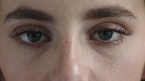 close-up-beautiful-woman-blue-eyes-looking-at-camera-blinking-freckles-makeup