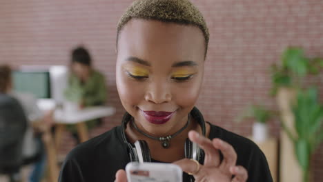 portrait-of-trendy-young-african-american-woman-texting-browsing-using-smartphone-social-media-app-in-contemporary-office-workspace