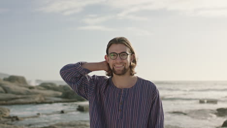 Porträt-Eines-Netten-Mannes-Mit-Brille,-Der-Am-Strand-Haare-Berührt