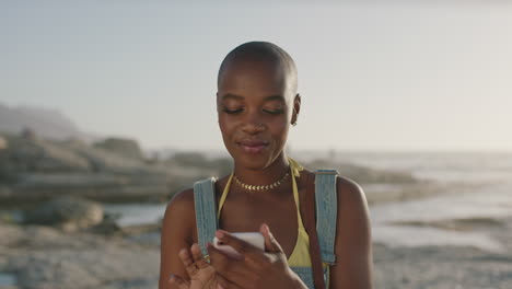portrait-of-african-american-woman-taking-selfie-using-phone-at-beach
