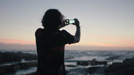 young-man-taking-photo-using-phone-at-beach-early-morning-evening