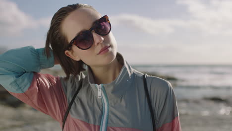 Porträt-Einer-Coolen-Frau,-Die-Selbstbewusst-Am-Strand-Haare-Berührt-Und-Eine-Sonnenbrille-Trägt