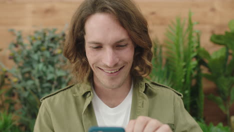 close-up-portrait-of-young-caucasian-man-smiling-enjoying-browsing-online-social-media-app-using-smartphone-technology