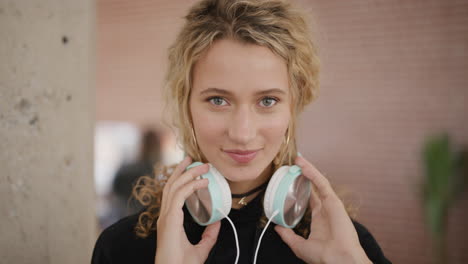 portrait-of-beautiful-young-blonde-woman-student-listening-to-music-removes-headphones-smiling-enjoying-leisure-activity-entertainment