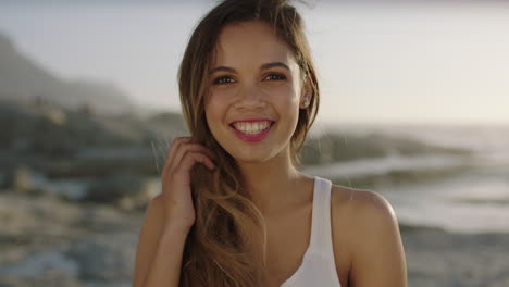 Porträt-Einer-Schönen-Hispanischen-Frau,-Die-Am-Strand-Lächelt-Und-Ihr-Haar-Berührt